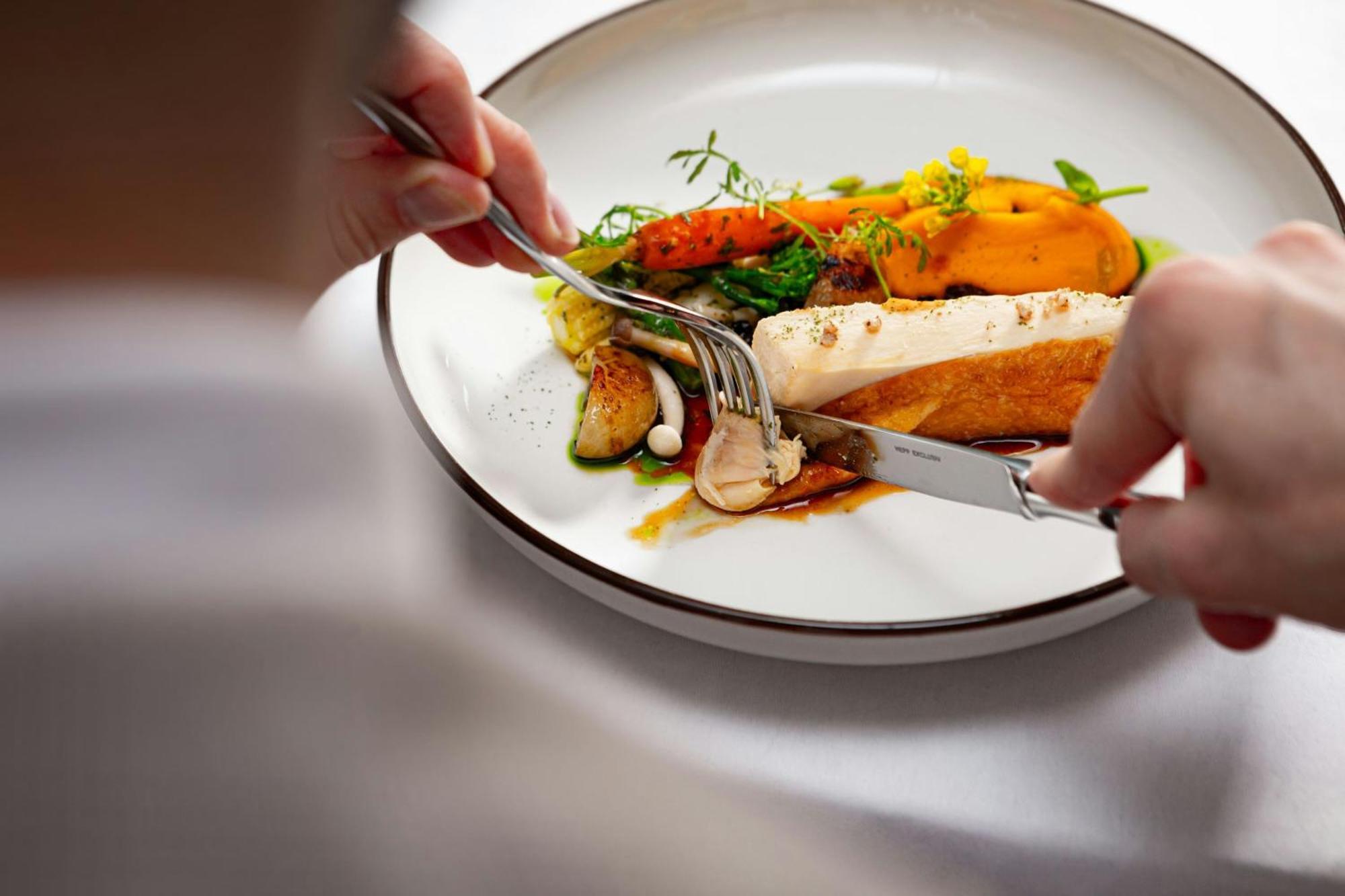 Grand Hotel River Park, A Luxury Collection Hotel, Bratislava Exteriör bild A person using a knife and fork to cut into a meal